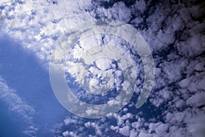 The vast blue sky with small panoramic clouds.