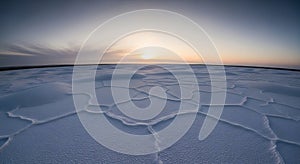 Vast salt flat surface with hexagonal patterns under a soft sunset sky