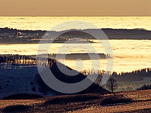 Dimensional landscape by a sea of clouds in the valleys, golden at sunset in Rhoen, Germany, in late winter photo