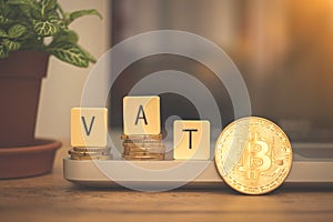 VAT with bitcoin cryptocurrency concept business background. Modern taxes with crypto coin. Desk with laptop, VAT word