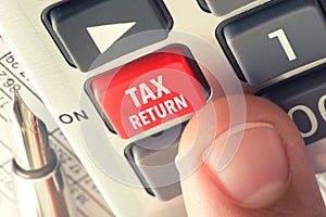 VAT or tax return concept with hand calculator buttons and finger pressing keyboard