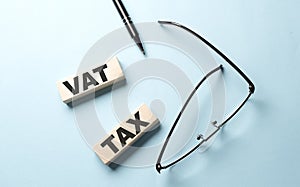 VAT TAX text on the wooden block ,blue background
