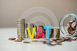 VAT text with golden coin growing money stairs or stack and glass jar on wooden table. business, investment, retirement planning,