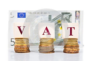 VAT or Value Added Tax concept with stack of coin and EURO currency as backdrop