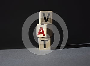 VAT - Value Added Tax symbol. Wooden cubes with word VAT. Beautiful grey background. Business and Value Added Tax concept. Copy