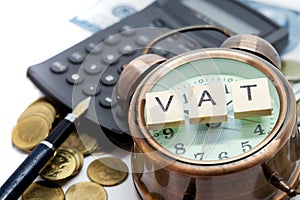 VAT word on Alarm clock and stacks coins photo