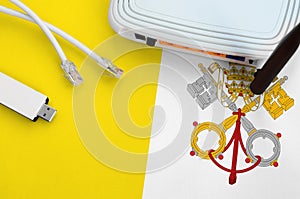 Vatican City State flag depicted on table with internet rj45 cable, wireless usb wifi adapter and router. Internet connection