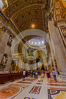 VATICAN, ITALY - JUNE 13, 2015: Indoor view of Vatican Basilica, Sain Peter. Tourists enter and looking to scultures