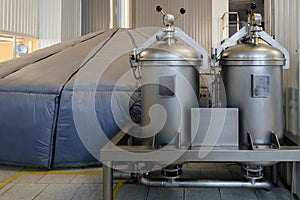 Vats for mash fermentation and cylinders with gas in and hop dispenser in modern brewery