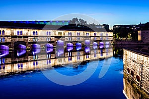 The Vauban Dam illuminated at nightfall in the Petite France historic quarter in Strasbourg, France