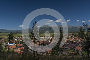 Výhľad na panorámu obce Važec s Vysokými Tatrami za slnečného letného dňa