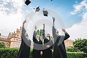 We`ve finally graduated!Graduates near university are throwing up hats in the air