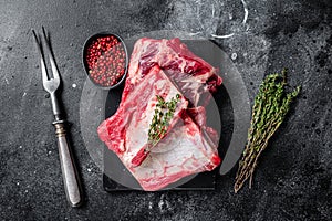 Veal beef Short Ribs, raw sparerib on marble board. Black background. Top view photo