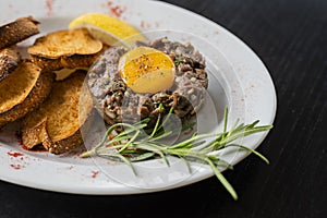 veal or beef tartar dish raw minced meat in a restaurant with rosemary