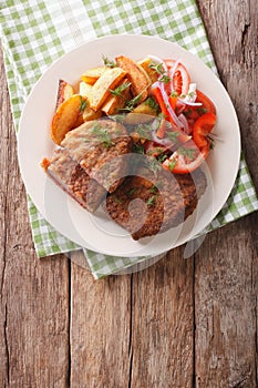 Veal breaded rump steak and garnished with vegetables close-up.