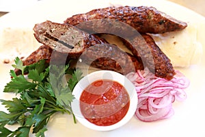Veal lula kebab with red onions and sauce