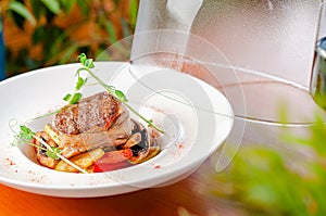 Veal medallion with vegetables on plate. Restaurant serving dish