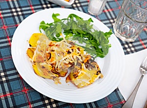 Veal Orloff served on baked potato with fresh arugula