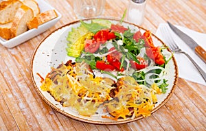 Veal Orloff served with baked potato and vegetable salad