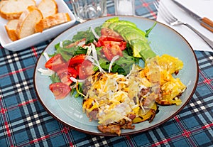 Veal Orloff served with baked potato and vegetable salad