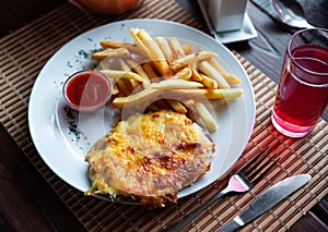 Veal Orloff served with fried potatoes and tomato sauce