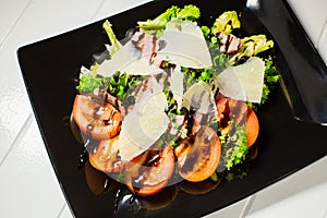 Veal steak salad with arugula, lettuce, tomato, olives and parmesan cheese