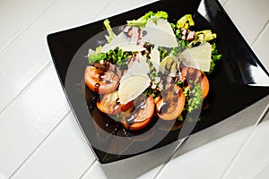 Veal steak salad with arugula, lettuce, tomato, olives and parmesan cheese