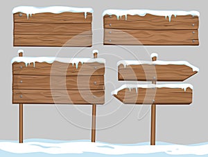 Vector cartoon set of blank wooden signs covered with snow and i