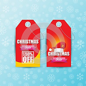 Vector Christmas sales paper banner or tag label with red santa hat on snowy blue background with falling snowflakes