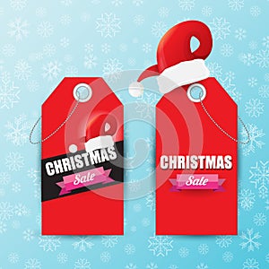 Vector Christmas sales paper banner or tag label with red santa hat on snowy blue background with falling snowflakes