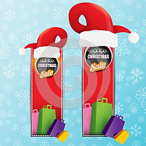 Vector Christmas sales paper banner or tag label with red santa hat on snowy blue background with falling snowflakes