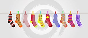 Vector colorful socks on gray background are hanging on rope photo