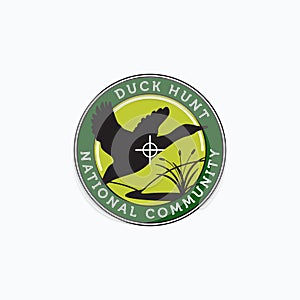 Vector of flying duck, hill, creek, and cattail with aim dot good for duck hunter community logo, badge, emblem, and sticker