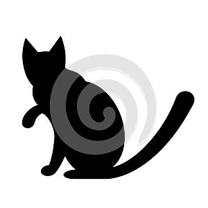 Vector illustration of a black silhouette of a cat. The pet sits with its paw raised. Isolated icon on white background. Simple