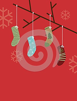 Vector illustration of Christmas socks hanging from tree branch against a red snowflake holiday background