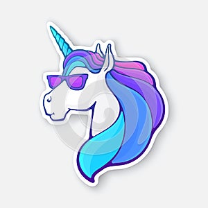 Sticker of fairy tale unicorn head in sunglasses with a rainbow mane