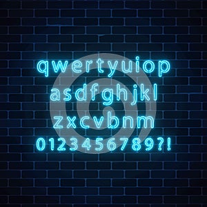 Vector neon style font. Glowing neon alphabet with lowercase letters on dark brick wall background.