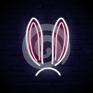 Vector pink and white neon rabbit ears isolated on dark brick background.