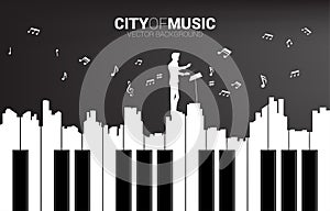 Vector silhouette of conductor with piano key shaped the the big city outline silhouette.