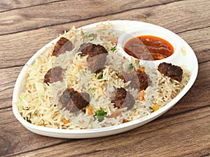 Veg manchurian fried rice, made of fried mixed vegetables balls along with rice is tossed in soy tomato based sauce, indo chinese