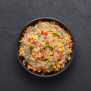 Veg Schezwan Fried Rice in black bowl at dark slate background. indo-chinese cuisine dish