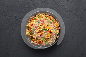 Veg Schezwan Fried Rice in black bowl at dark slate background. indo-chinese cuisine dish photo