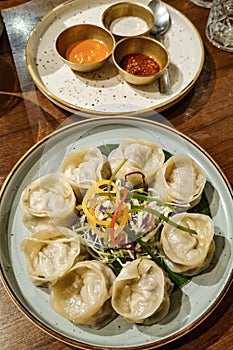 Veg steamed momo. Nepalese Traditional dish Momo stuffed with vegetables and then cooked and served with sauce on a ceramic plate