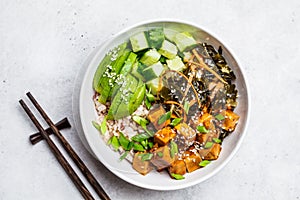 Vegan ahi poke bowl with tofu, rice, seaweed, avocado and cucumber, white background, top view