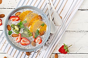 Vegan almond milk chia seeds pudding with strawberries, orange and kiwi.