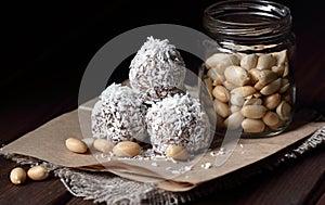 Vegan balls with dates, peanut butter and coconut on dark moody background