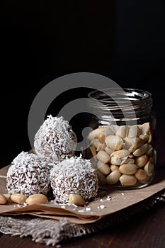 Vegan balls with dates, peanut butter and coconut on dark moody background