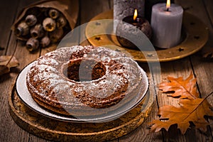Vegan banana cake, background decorated with autumn and winter candles
