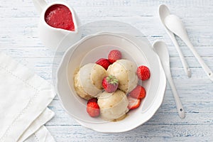 Vegan banana ice cream with strawberry sauce and fresh strawberries