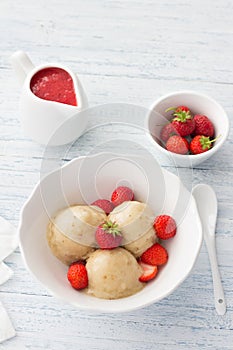 Vegan banana ice cream with strawberry sauce and fresh strawberries